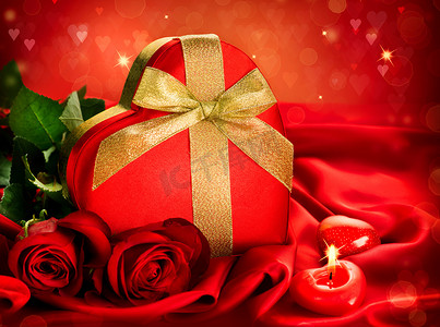 红丝绸上的情人节红耳礼物和红玫瑰花