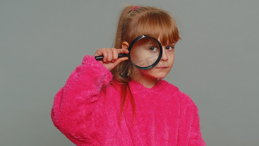 好奇的青春期前儿童拿着放大镜靠近脸滑稽的眼睛搜索分析
