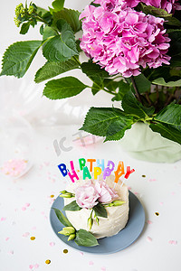 非常漂亮的便当蛋糕，装饰着新鲜的洋桔梗花，背景是糖果和生日快乐题词，气球，鲜花。