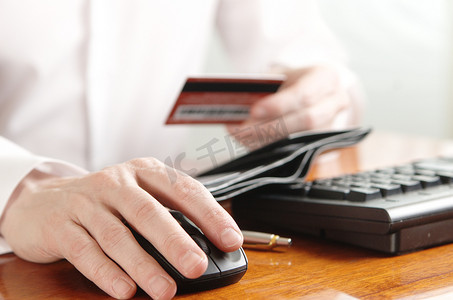 钱包银行卡摄影照片_电脑键盘上有钱包和银行卡的商人的手