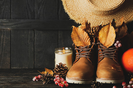 木制背景上带靴子和树叶的秋装概念