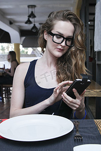 戴眼镜的美女在手机上聊天