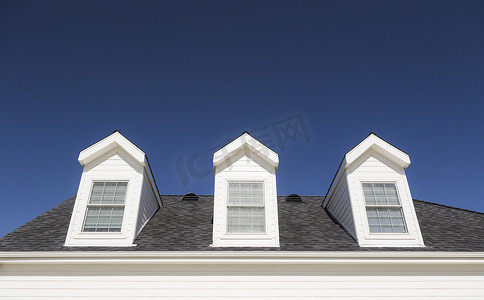 天空深蓝摄影照片_房子的屋顶和窗户映衬着深蓝的天空