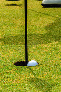 高尔夫球手将高尔夫球放入洞中