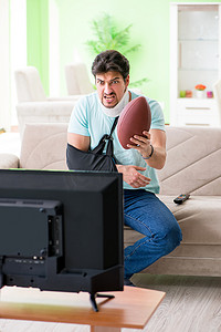 颈部和手臂受伤的男子在电视上看美式足球