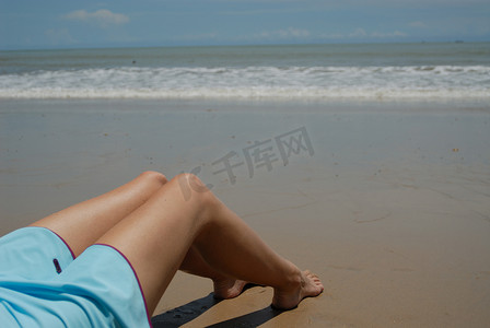 美丽高大的黑发女人在海滩上的股票照片