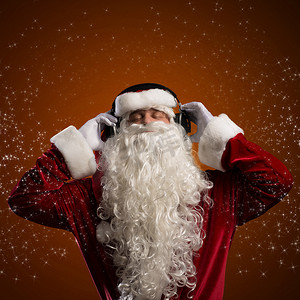 冬天的音乐背景摄影照片_圣诞老人正在听音乐