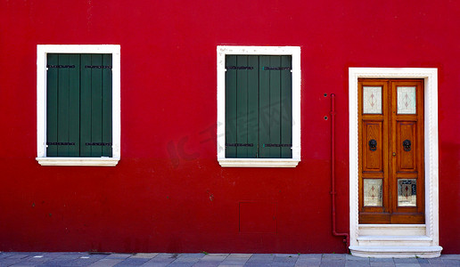 红墙上的木门和两扇窗户