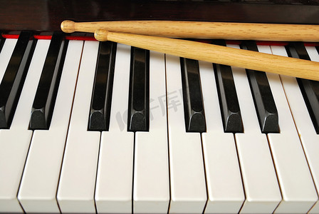 键盘黑色摄影照片_钢琴键盘上的鼓棒