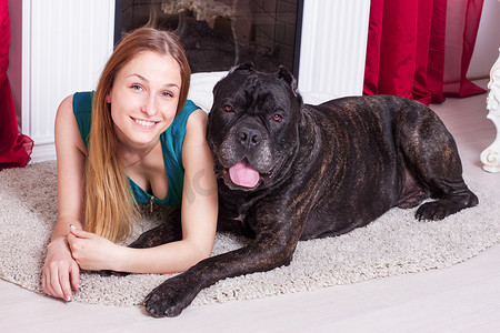 女人和他的大狗 Cane Corso 在壁炉旁的家里