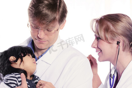 害怕的孩子摄影照片_照顾害怕的儿童患者的两位医生