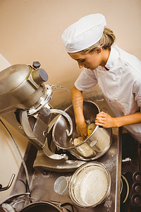 大型搅拌机摄影照片_面包师使用大型搅拌机混合面团