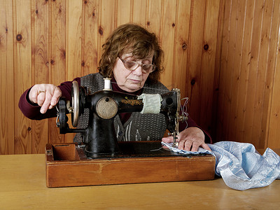 老妇人在缝纫机上缝纫