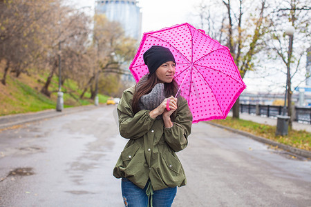秋雨天带伞走路的年轻女子