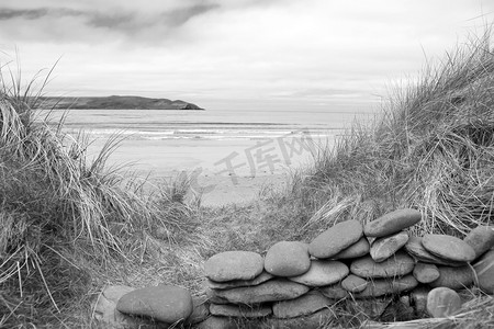 风菲斯风摄影照片_黑白相间的美丽海滩上的石墙风雨棚