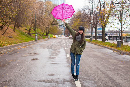 秋雨天带伞走路的年轻女子