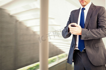 楼梯装潢摄影照片_专注的商人在手机上发短信的合成图像