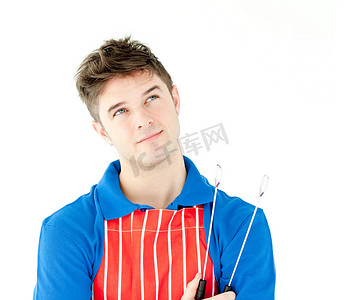 厨师动画摄影照片_拿着炊具的体贴的年轻厨师