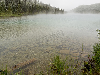 冒热气摄影照片_夏日降雪后清澈的山湖冒着热气