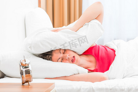 女人睡觉摄影照片_女人捂着耳朵枕头睡着了