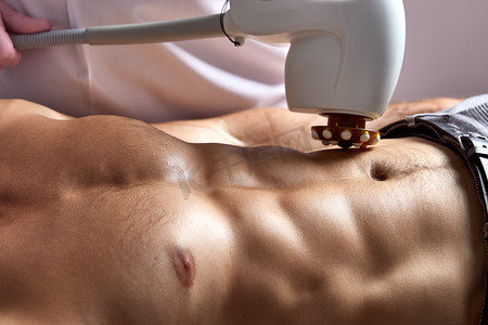 在美容诊所接受现代设备减脂皮肤提升身体治疗的男子