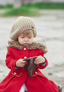 一件红色外套的迷人的婴孩看钱包