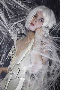 穿着白色高级定制礼服的漂亮女人，小提琴，音乐概念