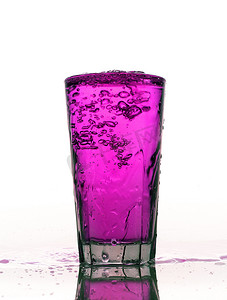 柠檬水溅摄影照片_杯飞溅的粉红色柠檬水隔离在白色背景