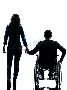 人和手摄影照片_坐在轮椅上的残疾人和手牵着手的女人剪影