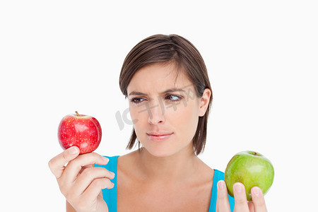 苹果开摄影照片_拿着两个苹果并且看红色一个的少年