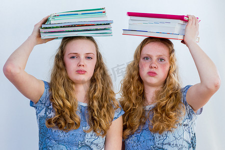 书籍课本摄影照片_两个头顶着课本的女学生