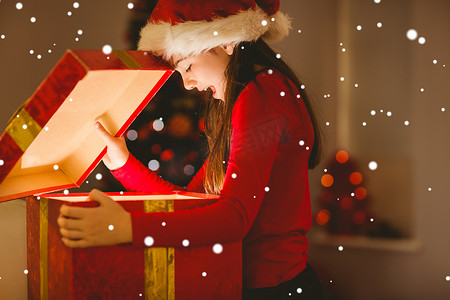 节日小女孩打开发光圣诞礼物的合成图像