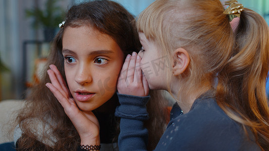 十几岁的孩子在耳边耳语新闻谣言给小妹妹小女孩分享秘密八卦玩得开心