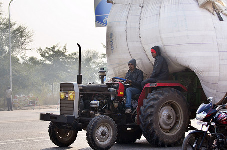印度斋浦尔-2014 年 12 月 30 日：印度男子在印度拉贾斯坦邦斋浦尔驾驶严重超载的卡车。