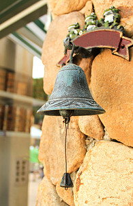 垂悬在石墙上的古色古香的响铃