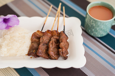 古代烧饭摄影照片_烤猪肉、猪排、叉烧饭和热牛奶 T