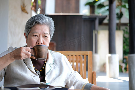 咖啡茶摄影照片_年长的老年妇女喝咖啡茶。