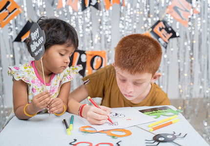 绘制星点摄影照片_有选择地专注于画手，孩子们忙于制作或绘制万圣节道具 — 万圣节、假期和儿童节庆典和准备的概念。