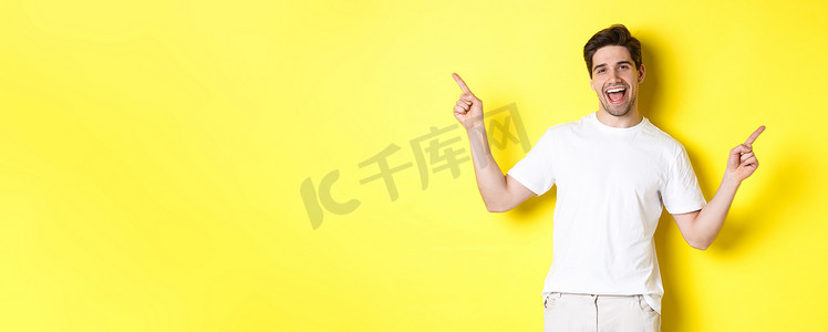 左右摄影照片_快乐时尚的男人展示了两种变体，在左右宣传片上向侧面指指点点，站在黄色背景上