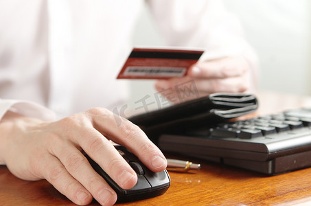 钱包银行卡摄影照片_电脑键盘上有钱包和银行卡的商人的手