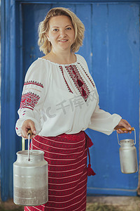 漂亮的大锅摄影照片_女主在绣花衣服上加奶罐。