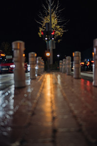 交通路障柱护柱和人行道由汽车前灯和交通灯照亮