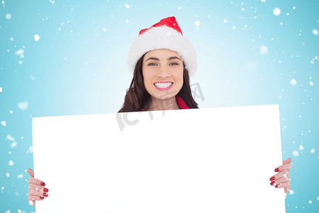 戴着圣诞老人帽子、微笑的黑发女郎展示白色海报的合成图像