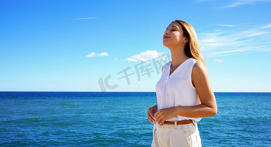 年轻女子在海上放松呼吸新鲜空气的肖像