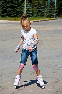 蓝色溜冰鞋摄影照片_夏天穿着溜冰鞋的可爱女孩