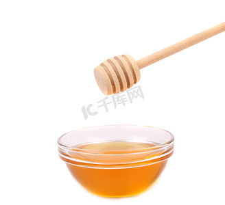 可爱蜂蜜摄影照片_蜂蜜弓和木勺。