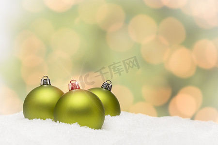 抽象背景下雪地上的绿色圣诞饰品