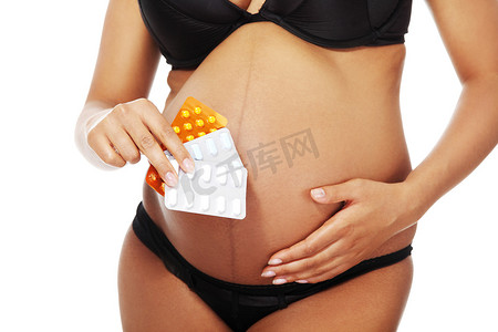 孕妇生病摄影照片_拿着药片的年轻美丽的孕妇