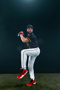 大棒球摄影照片_深色背景的棒球运动员。