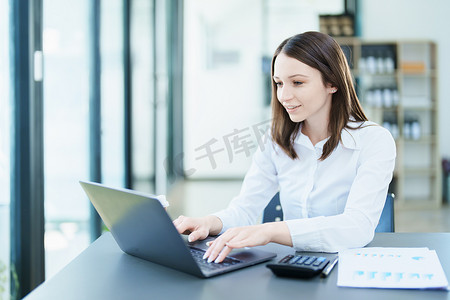 业务规划、使用计算机审计财务报表和营销的女商人肖像
